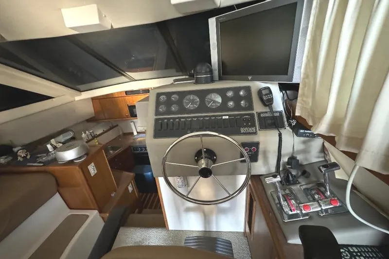Slide: The Image of 1999 Bayliner 3388 Command Bridge Motoryacht interior helm with steering wheel and control panel. - 11