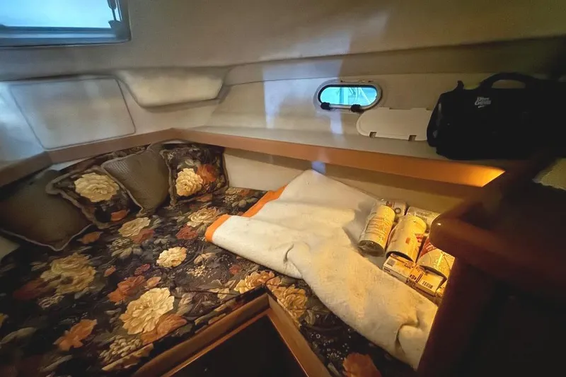 Slide: The Image of 1999 Bayliner 3388 Command Bridge Motoryacht cabin with floral bedding and porthole window. - 14