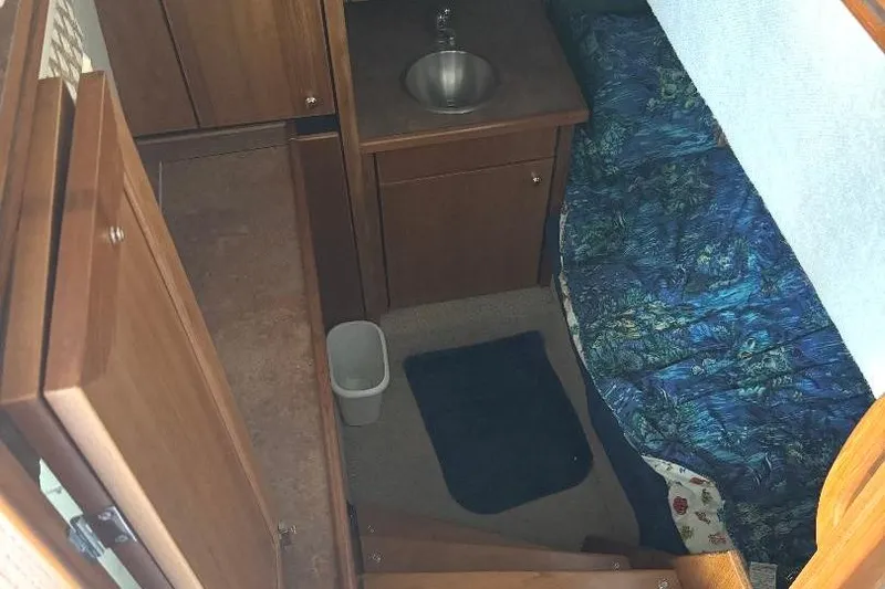 Slide: The Image of Interior of 1999 Bayliner 3388 Command Bridge Motoryacht with bed, sink, and wooden cabinetry. - 17