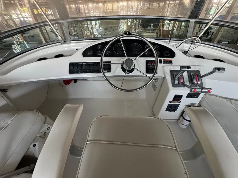 Slide: The Image of 1999 Bayliner 3388 Command Bridge Motoryacht helm with steering wheel and controls. - 19