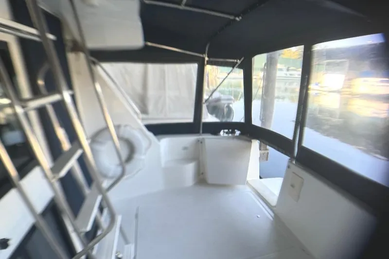Slide: The Image of 1999 Bayliner 3388 Command Bridge Motoryacht interior with covered seating area and water view. - 23