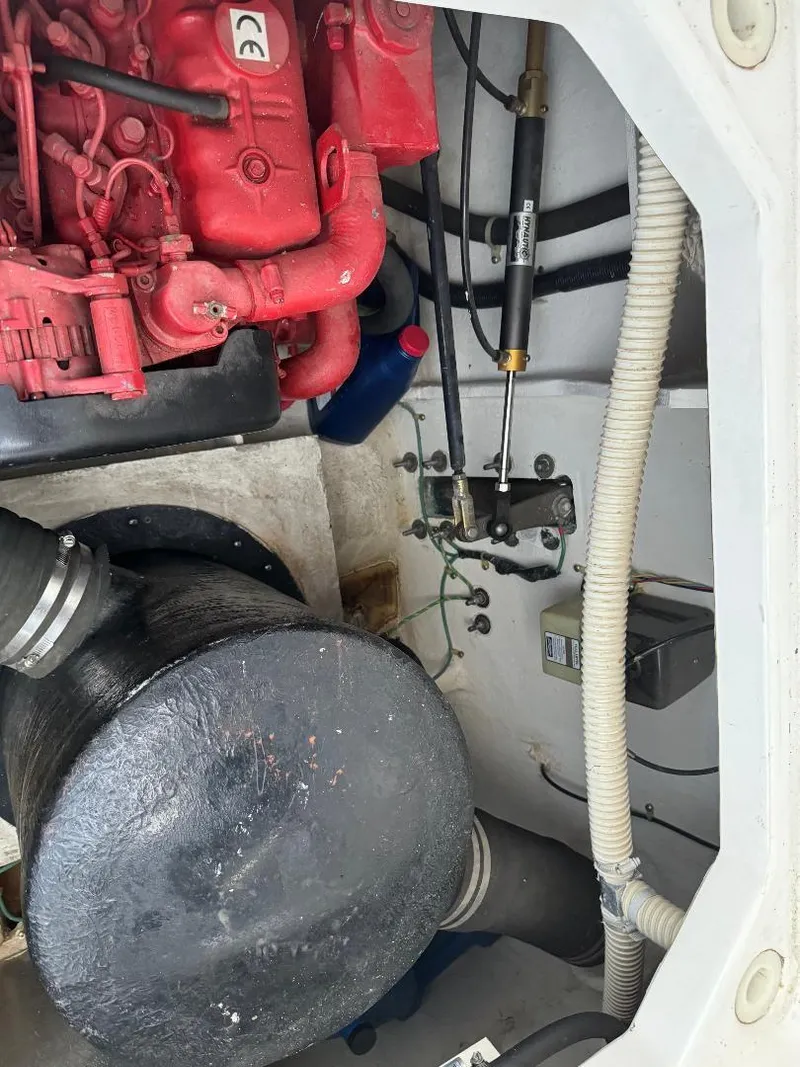 Slide: The Image of Engine compartment of 1999 Bayliner 3388 Command Bridge Motoryacht, featuring red engine components. - 26