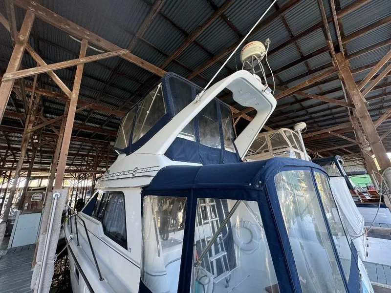 Slide: The Image of 1999 Bayliner 3388 Command Bridge Motoryacht docked under a covered marina. - 27