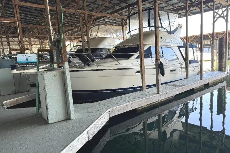 Slide: The Image of 1999 Bayliner 3388 Command Bridge Motoryacht docked in a covered marina. - 30