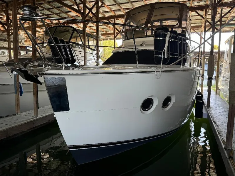 Slide: The Image of 1999 Bayliner 3388 Command Bridge Motoryacht docked in a covered marina. - 31