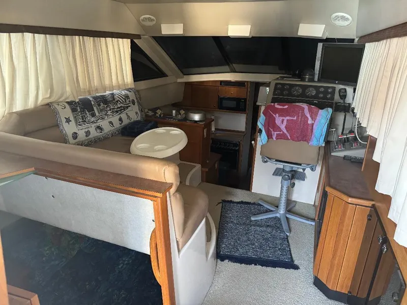 Slide: The Image of Interior of 1999 Bayliner 3388 Command Bridge Motoryacht, featuring seating, helm, and kitchenette. - 7