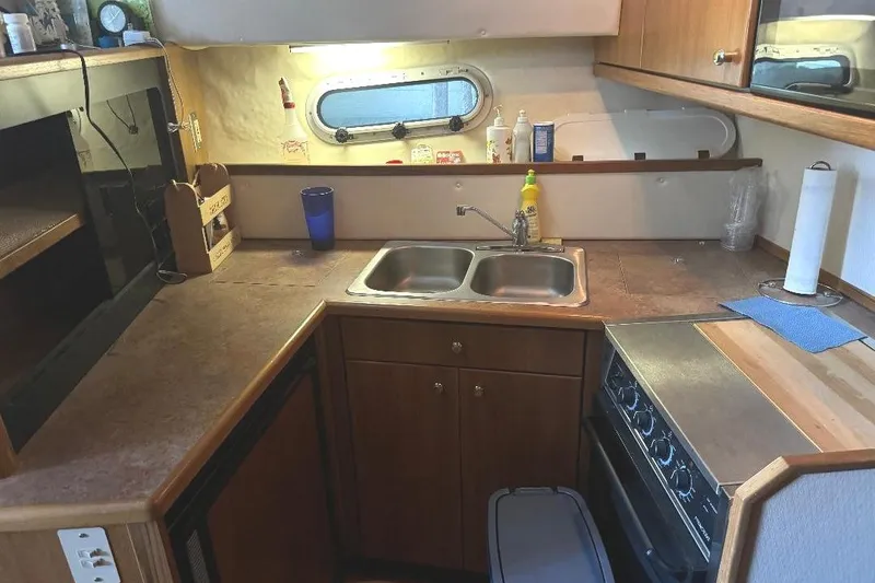 Slide: The Image of 1999 Bayliner 3388 Command Bridge Motoryacht kitchen with sink, stove, and countertop. - 9