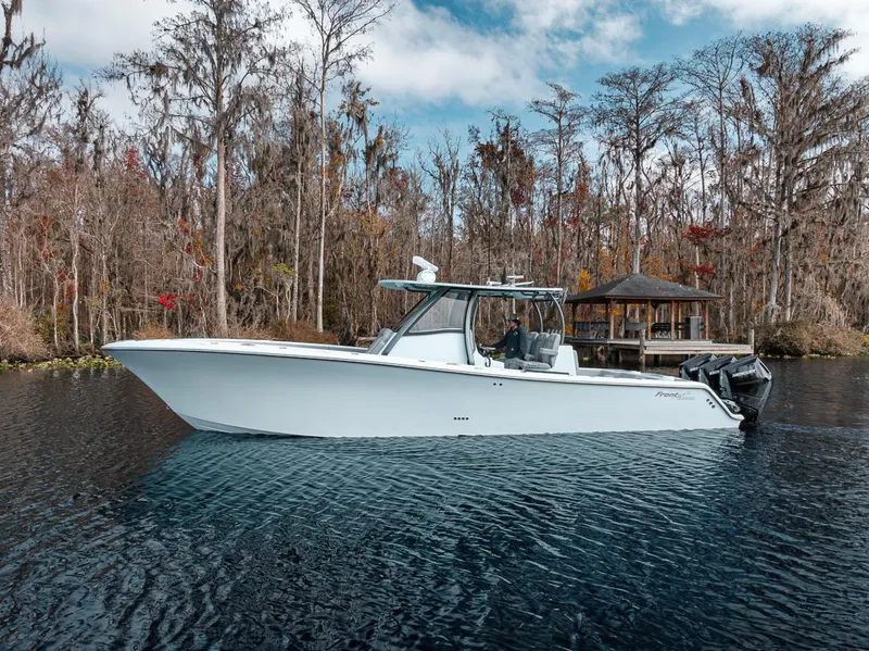 Slide: The Image of 2024 Front Runner 36 Center Console boat on a serene lake with autumn trees. - 1