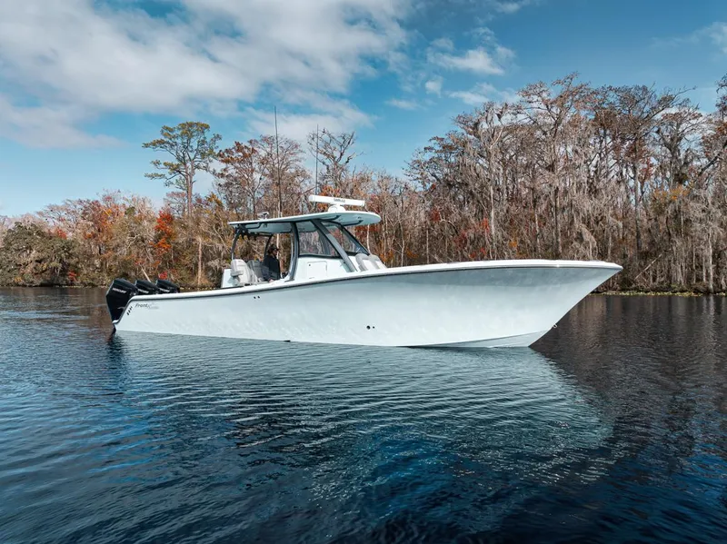 Slide: The Image of 2024 Front Runner 36 Center Console boat on a serene lake with autumn trees. - 12