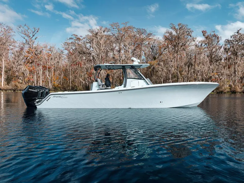 Slide: The Image of 2024 Front Runner 36 Center Console boat on calm water, surrounded by trees. - 13