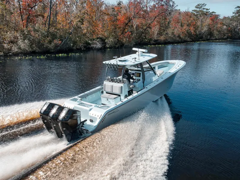 Slide: The Image of 2024 Front Runner 36 Center Console boat cruising on a scenic river with autumn foliage. - 18