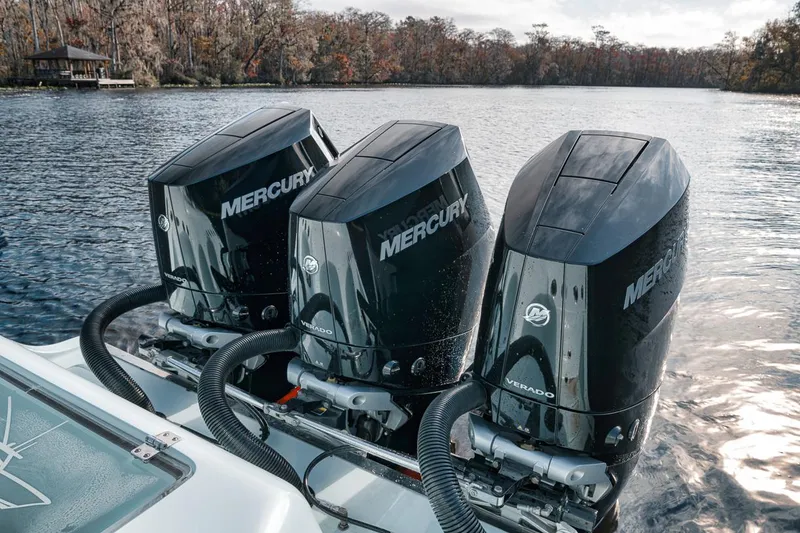 Slide: The Image of 2024 Front Runner 36 Center Console with triple Mercury outboard engines on a lake. - 26
