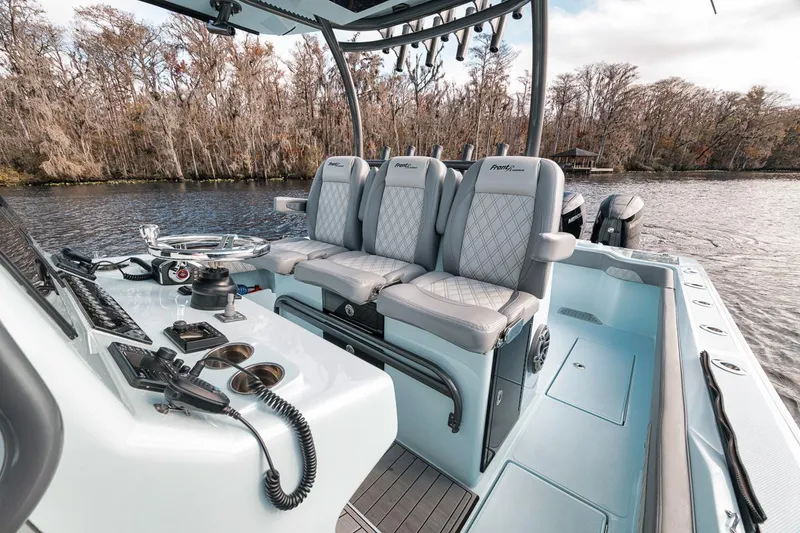 Slide: The Image of 2024 Front Runner 36 Center Console boat interior with seating and control panel on a lake. - 29
