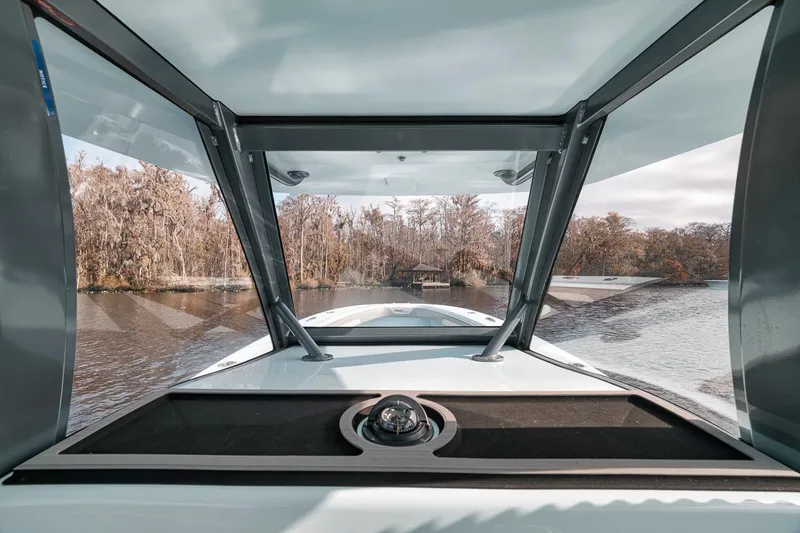 Slide: The Image of 2024 Front Runner 36 Center Console navigating a scenic river with lush trees. - 44