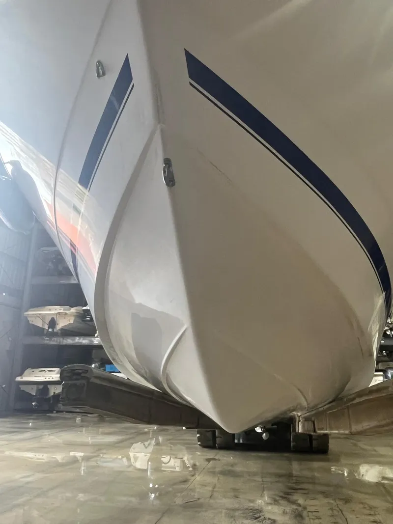Slide: The Image of 2001 Pro-Line 25 Sport boat hull with blue stripe in storage. - 10