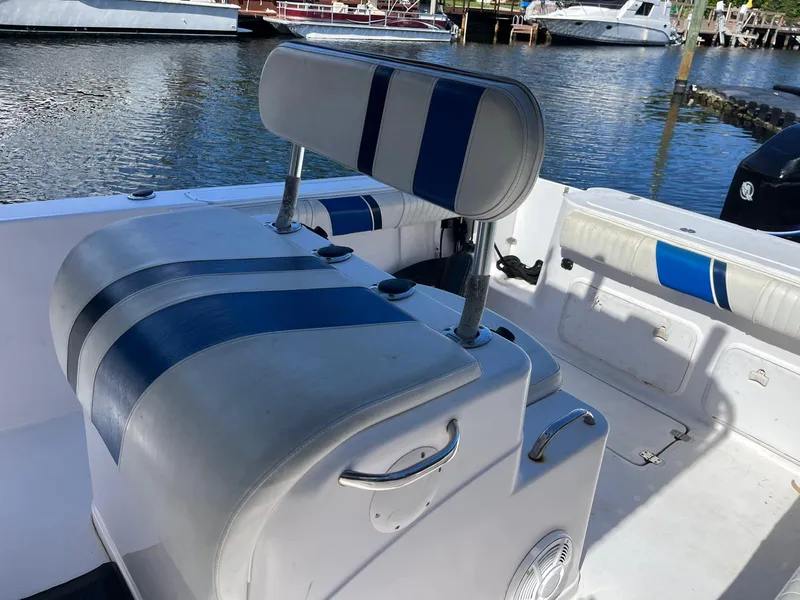 Slide: The Image of 2001 Pro-Line 25 Sport boat interior with blue and white seating by the water. - 19