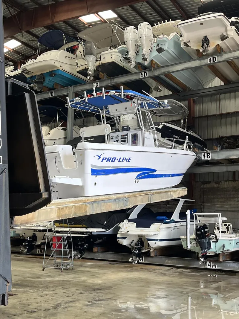 Slide: The Image of 2001 Pro-Line 25 Sport boat stored in a multi-level indoor marina. - 2