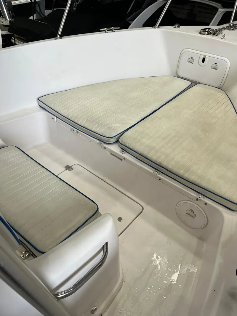 Slide: The Image of 2001 Pro-Line 25 Sport boat interior with cushioned seating and storage. - 21