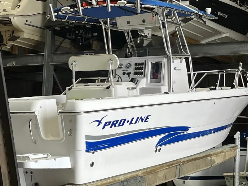 Slide: The Image of 2001 Pro-Line 25 Sport boat in storage, featuring white and blue design. - 3