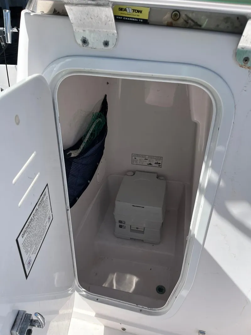 Slide: The Image of 2001 Pro-Line 25 Sport boat storage compartment with open door. - 38