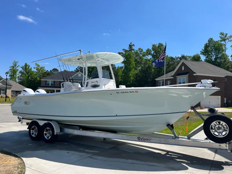 Slide: The Image of 2014 Sea Hunt Gamefish 27 boat on trailer in suburban driveway. - 1