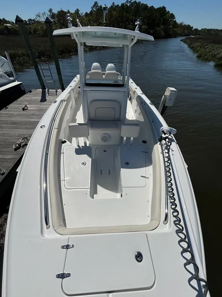 Slide: The Image of 2014 Sea Hunt Gamefish 27 boat with forward seating, docked on a calm river. - 7
