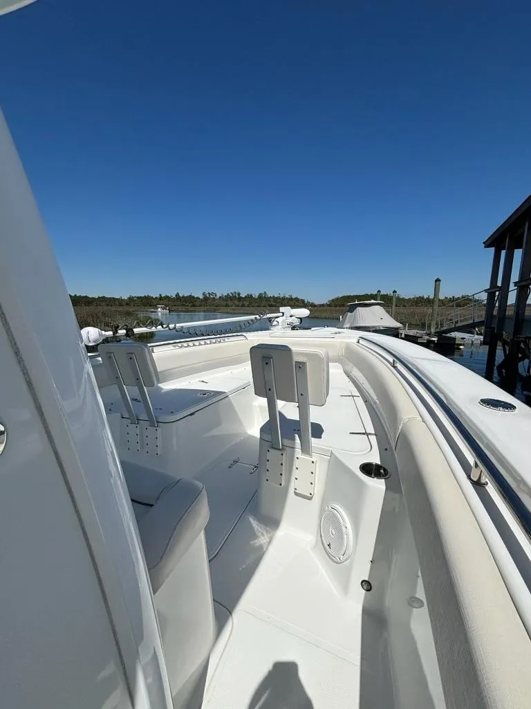 Slide: The Image of 2014 Sea Hunt Gamefish 27 boat with forward seating, docked under clear blue sky. - 8