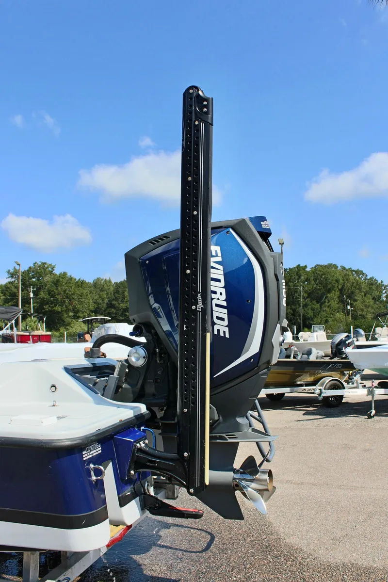 Slide: The Image of 2017 Tiburon ZX-25 boat with Evinrude outboard motor, parked outdoors. - 11