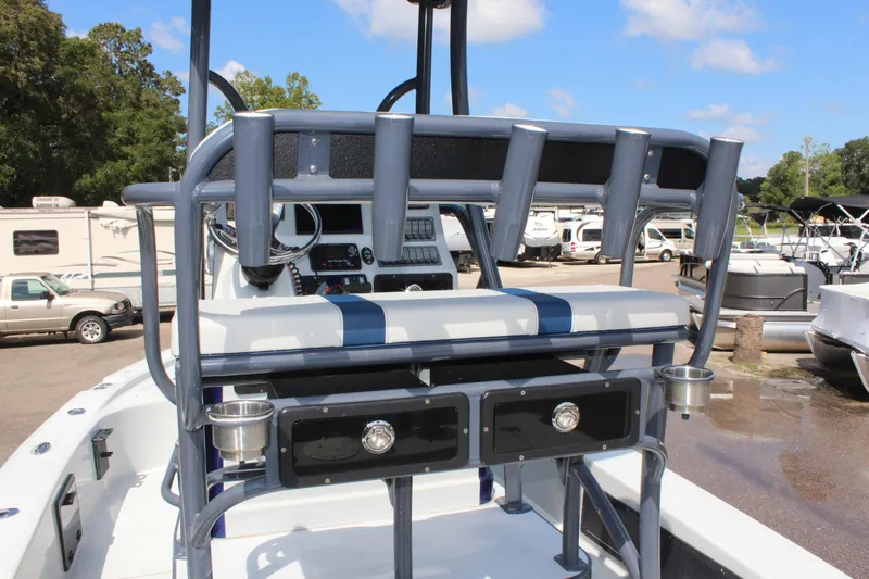 Slide: The Image of 2017 Tiburon ZX-25 boat interior with rod holders and seating, parked outdoors. - 17
