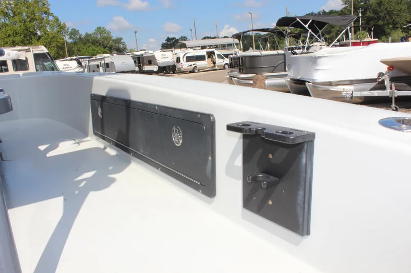 Slide: The Image of 2017 Tiburon ZX-25 boat interior with storage compartment and rod holder, docked near other boats. - 20