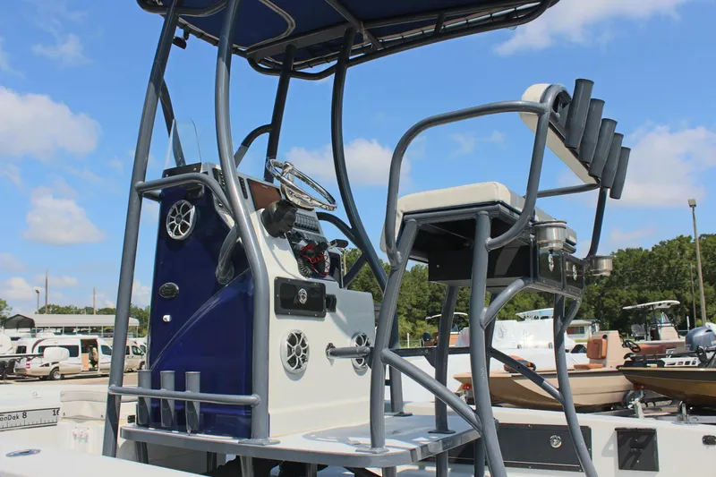 Slide: The Image of 2017 Tiburon ZX-25 boat console with seating and rod holders under a blue sky. - 35