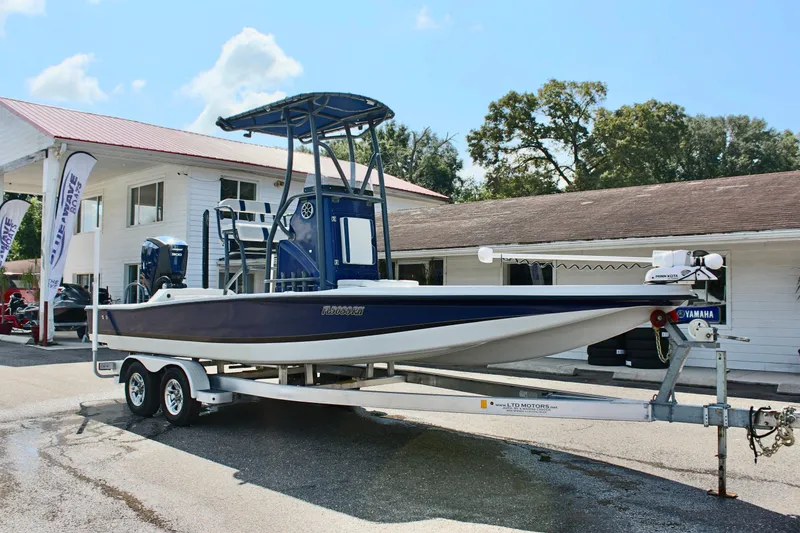Slide: The Image of 2017 Tiburon ZX-25 boat on trailer, parked outside a building under a clear sky. - 5