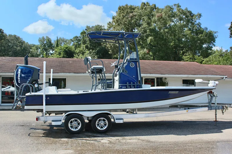 Slide: The Image of 2017 Tiburon ZX-25 boat on trailer, blue and white, parked outdoors. - 6