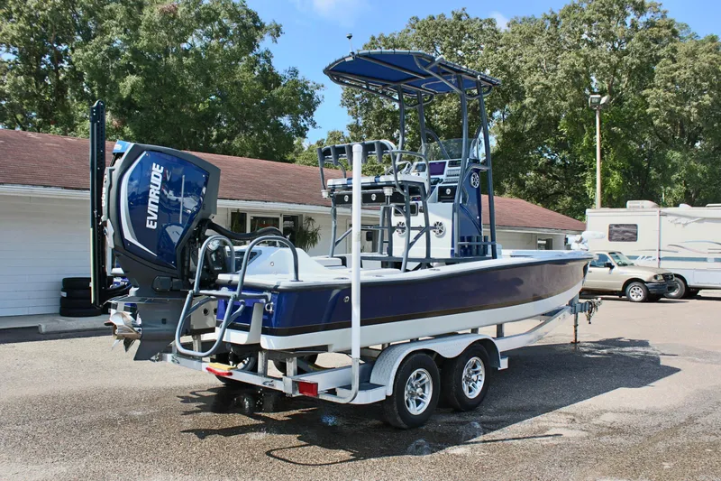 Slide: The Image of 2017 Tiburon ZX-25 boat with Evinrude engine on trailer, parked outdoors. - 8