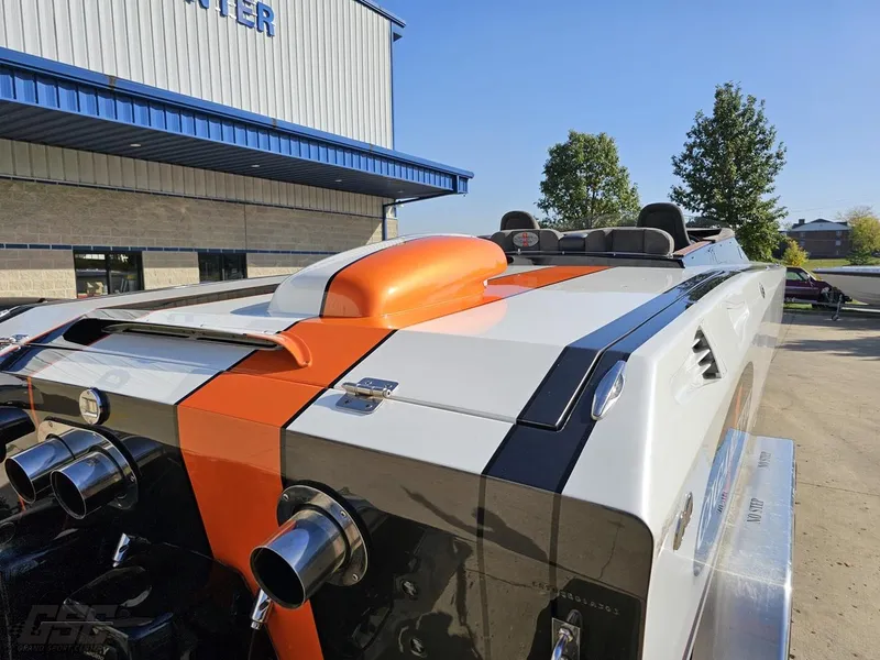 Slide: The Image of 2003 Cigarette 36 Gladiator boat with orange and black accents, parked outdoors. - 41