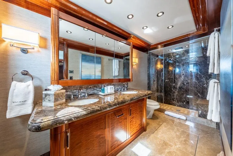 Slide: The Image of Luxurious yacht bathroom with marble countertops, wooden cabinetry, and glass shower in Westport W164, 2013. - 35