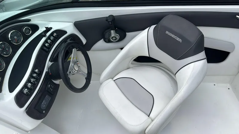 Slide: The Image of 2019 Rinker 21QX BR boat interior with steering wheel and white captain's chair. - 5