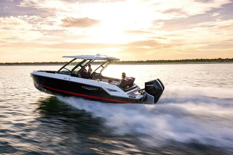 Slide: The Image of 2025 Monterey Elite 30 OB boat cruising on a serene lake at sunset. - 14