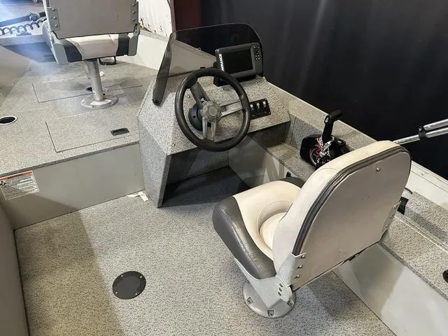 Slide: The Image of 2019 Starcraft 16 Patriot boat interior with steering console and seating. - 7