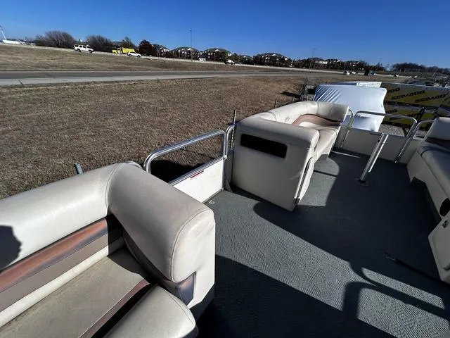 Slide: The Image of 2003 Fisher FREEDOM 240 DELUXE pontoon boat interior with beige seating on a sunny day. - 13