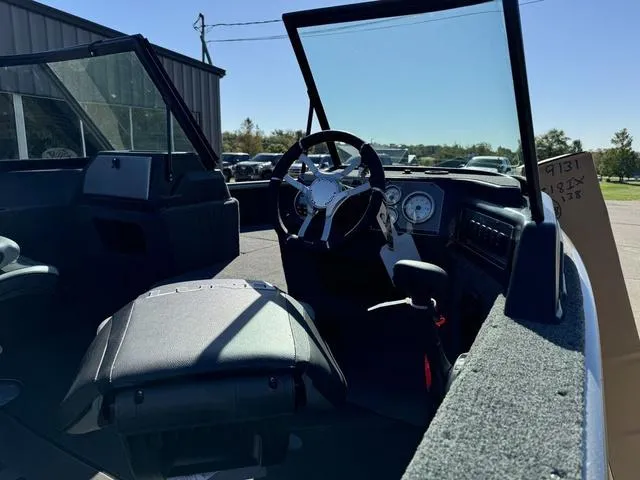 Slide: The Image of Interior view of 2025 Lund 1875 Impact XS Sport boat, featuring steering wheel and dashboard. - 11