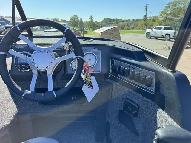 Slide: The Image of 2025 Lund 1875 Impact XS Sport boat dashboard with steering wheel and control panel. - 12