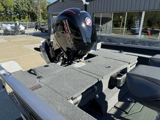 Slide: The Image of 2025 Lund 1875 Impact XS Sport boat with powerful outboard motor in a showroom setting. - 13