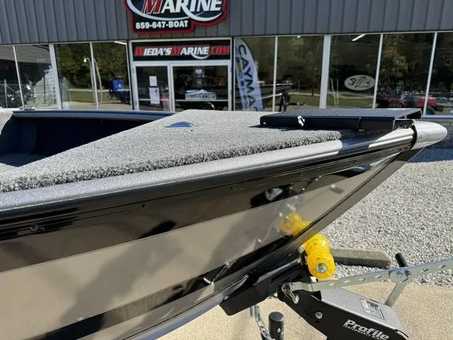 Slide: The Image of 2025 Lund 1875 Impact XS Sport boat on trailer outside marine dealership. - 18