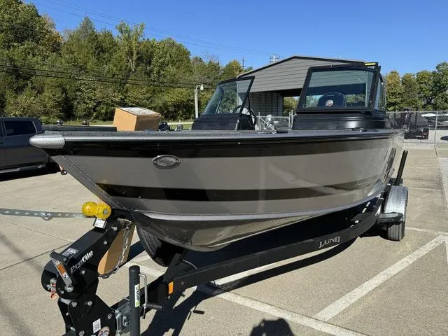 Slide: The Image of 2025 Lund 1875 Impact XS Sport boat on trailer in parking lot. - 21