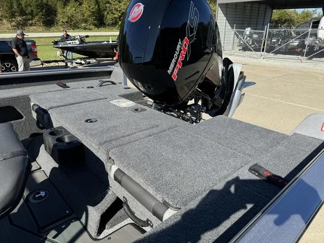 Slide: The Image of 2025 Lund 1875 Impact XS Sport boat with Mercury Pro XS engine, parked outdoors. - 25