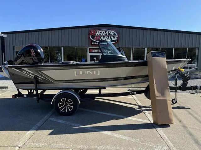 Slide: The Image of 2025 Lund 1875 Impact XS Sport boat displayed outside a marine dealership. - 5
