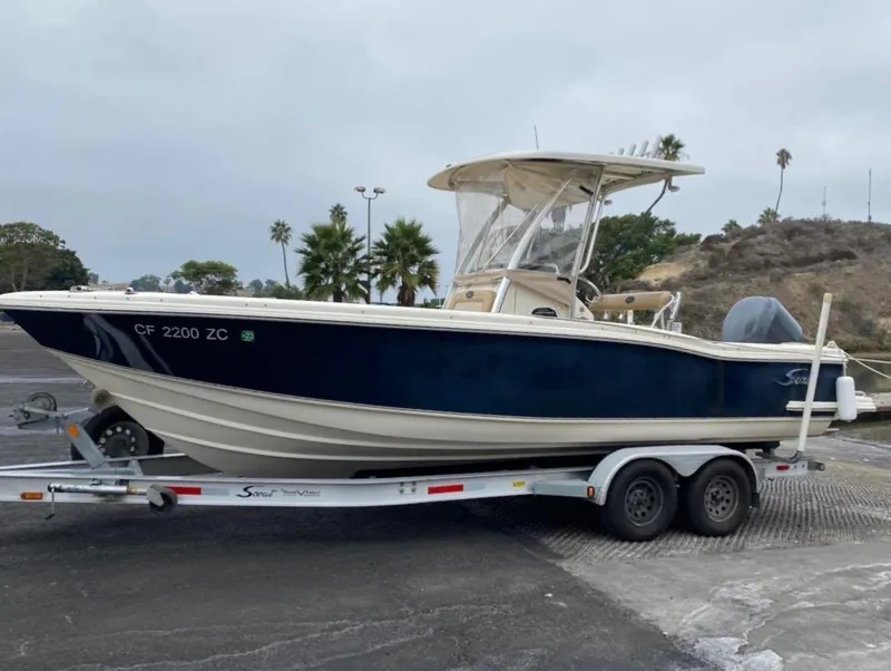 The Image of 2007 Scout 242 Sportfish boat on trailer, parked outdoors. - 0
