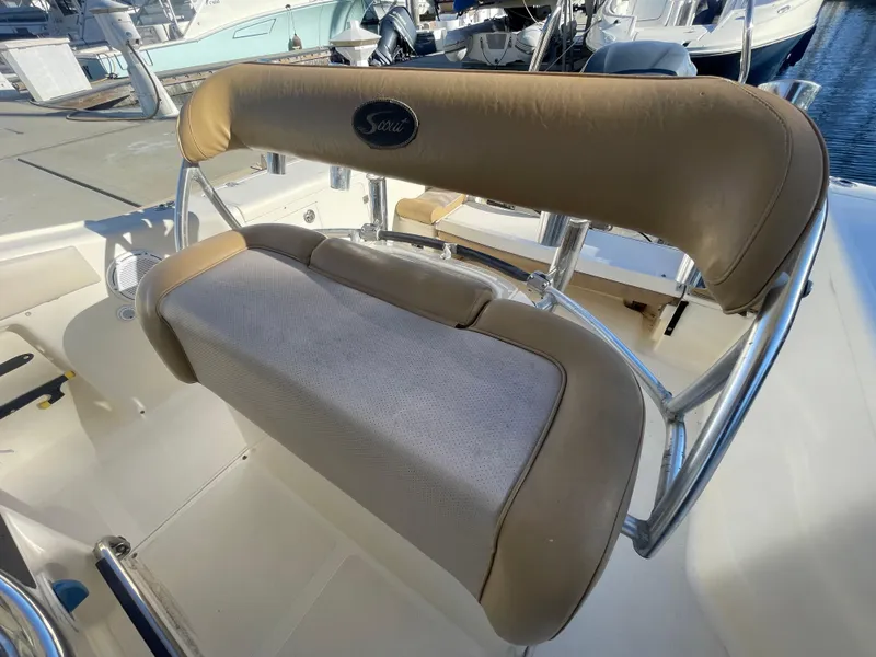 Slide: The Image of 2007 Scout 242 Sportfish boat seat with beige upholstery at a marina. - 14