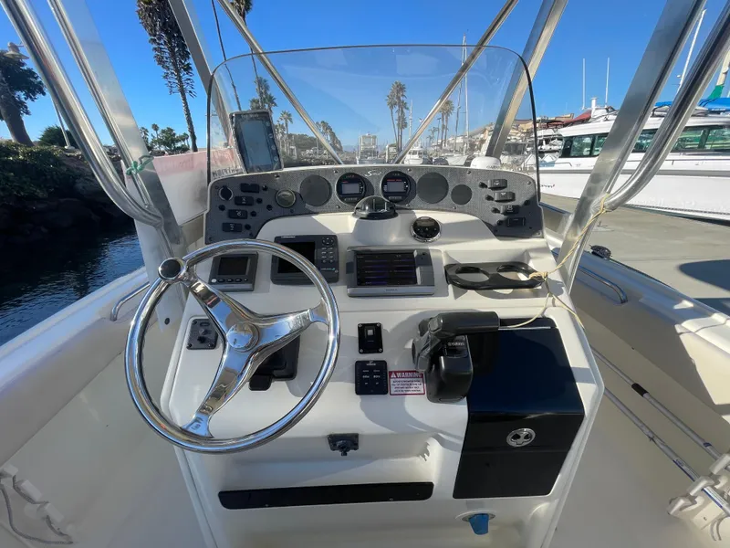 Slide: The Image of 2007 Scout 242 Sportfish boat console with steering wheel and navigation controls. - 17